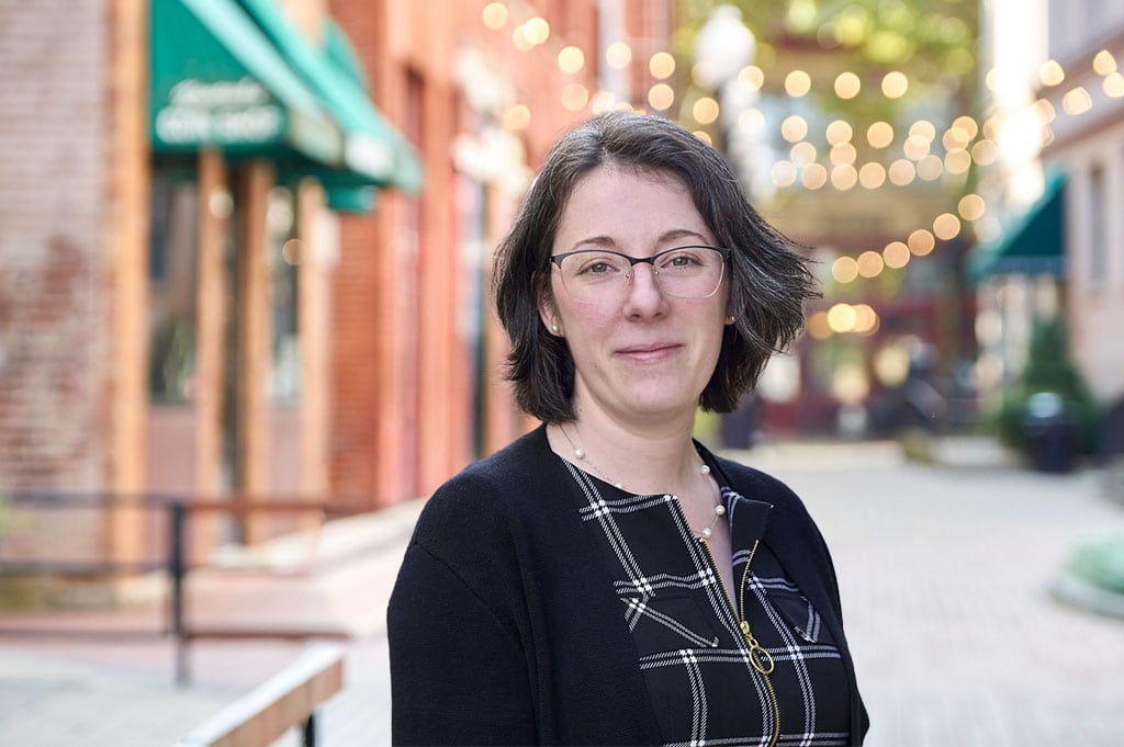Portrait of a woman in downtown Kanawha Valley with string lights overhead.